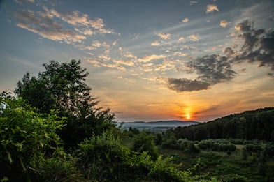 A colorful dawn breaks over the hills and forests of Berks County, PA in summer